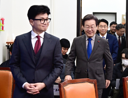 이재명 더불어민주당 대표와 한동훈(왼쪽) 국민의힘 비상대책위원장이 지난 12월29일 양당 지도부 상견례를 하기 위해 국회 민주당 대표실에 입장하고 있다.<연합뉴스 사진>